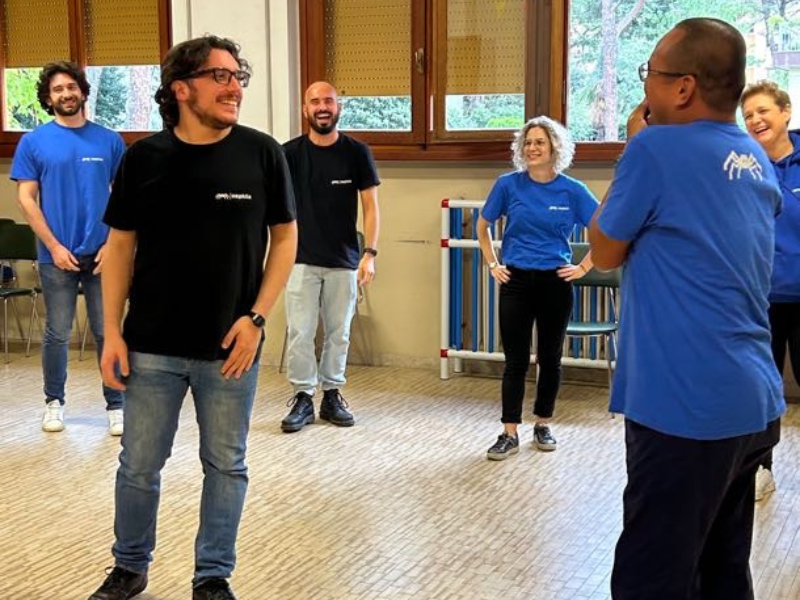 Nephila team smiling in a circle during an applied improv exercise.