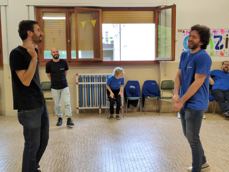 Two Nephila team members laughing during a paired improv exercise.