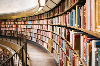 libreria che si estende in forma circolare con tanti libri disposti sugli scaffali