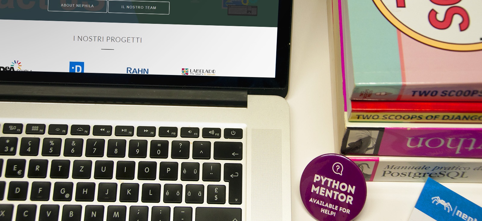 Laptop, books, and a Python Mentor pin on the Nephila office desk